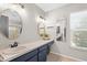 Bright bathroom boasts dual sinks, framed mirrors, and natural light from a large window at 205 Cavallini Dr, Nokomis, FL 34275