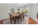 Dining room with hardwood floors, a wooden table, and sliding glass doors to the pool at 205 Cavallini Dr, Nokomis, FL 34275