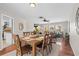 Dining area with hardwood floors, wooden table set for six, and view to the living room at 205 Cavallini Dr, Nokomis, FL 34275