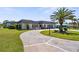 Beautiful single-story home with a circular driveway and a lush green lawn with palm trees at 205 Cavallini Dr, Nokomis, FL 34275