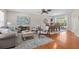 Open-concept living room and dining area with hardwood floors and lots of natural light at 205 Cavallini Dr, Nokomis, FL 34275