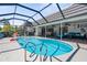 Screened-in pool with a covered patio with comfortable seating and dining area at 205 Cavallini Dr, Nokomis, FL 34275