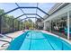 Stunning in-ground pool with screen enclosure, shallow steps, and an outdoor dining space at 205 Cavallini Dr, Nokomis, FL 34275