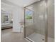 Bathroom with a glass shower, white door and view into the primary bedroom at 20591 Ovid Ln, Venice, FL 34293