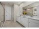 Bright bathroom with double sinks, white cabinets, granite countertops and a glass enclosed shower and tub at 20591 Ovid Ln, Venice, FL 34293