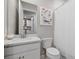 Bathroom featuring a white vanity, sink, toilet and shower with patterned art hanging at 20591 Ovid Ln, Venice, FL 34293