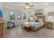 Bright bedroom featuring a comfortable king-sized bed, decorative pillows, and a serene view from the windows at 20591 Ovid Ln, Venice, FL 34293