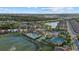 Extensive aerial view highlighting a community's clubhouse, pool, tennis courts, and lush landscaping near a lake at 20591 Ovid Ln, Venice, FL 34293