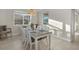 Dining room with a white table setting, natural light, and a view to the screened pool and backyard area at 20591 Ovid Ln, Venice, FL 34293
