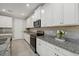 Kitchen features white cabinets, granite countertops, and modern appliances at 20591 Ovid Ln, Venice, FL 34293