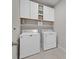 Clean laundry room with upper cabinets and modern washer and dryer at 20591 Ovid Ln, Venice, FL 34293