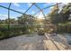 Screened-in patio featuring a comfortable seating area and view of mature landscaping at 20591 Ovid Ln, Venice, FL 34293