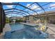 Screened pool and spa area includes outdoor dining, barbecue, basketball hoop, with a view of the fenced yard at 20591 Ovid Ln, Venice, FL 34293