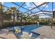 Screened pool and spa area with patio seating, basketball hoop, and tall palms visible beyond the backyard fence at 20591 Ovid Ln, Venice, FL 34293