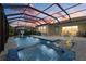 Screened pool and spa with outdoor dining and lush landscaping at sunset create a relaxing backyard atmosphere at 20591 Ovid Ln, Venice, FL 34293