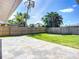 Landscaped backyard with a stone patio and lush green lawn, perfect for outdoor entertaining and relaxation at 2108 Lee Ln, Sarasota, FL 34231