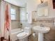 Bathroom featuring tile walls, bathtub and shower, and a modern white sink and toilet at 2108 Lee Ln, Sarasota, FL 34231