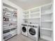 Bright laundry room with modern washer/dryer, storage shelves, and space for organization at 2108 Lee Ln, Sarasota, FL 34231