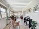 Bright sunroom with a piano, comfortable wicker chair, and tile flooring, ideal for music and relaxation at 2108 Lee Ln, Sarasota, FL 34231