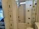 Shower and toilet in the bathroom with patterned shower curtain and built in shelving at 22 Nautical Dr, North Port, FL 34287