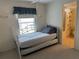 Bedroom featuring a daybed with trundle and an ensuite bathroom with patterned shower curtain at 22 Nautical Dr, North Port, FL 34287