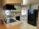 Functional kitchen layout with black appliances, light wood cabinets, and access to the dining area at 22 Nautical Dr, North Port, FL 34287