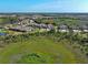 Aerial view of the home nestled among other homes and wooded area at 220 Sarezzo Cir, Nokomis, FL 34275