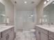 Bright bathroom featuring double vanity, granite countertops, and a glass enclosed shower with a tiled floor at 220 Sarezzo Cir, Nokomis, FL 34275