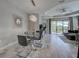Dining and living room featuring modern lighting, a glass table, and sliding doors to the outdoors at 220 Sarezzo Cir, Nokomis, FL 34275