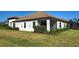 Exterior view features a home with white walls, a tile roof, and a well-maintained lawn at 220 Sarezzo Cir, Nokomis, FL 34275