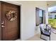 Front door and covered porch adorned with a wreath, enhanced by brown shutters and a welcoming ambiance at 220 Sarezzo Cir, Nokomis, FL 34275
