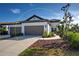 Charming single-story home featuring a two-car garage, well-manicured landscaping, and a welcoming walkway at 220 Sarezzo Cir, Nokomis, FL 34275