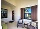 Inviting front porch with seating and decorative wreath, complemented by stylish shutters and windows at 220 Sarezzo Cir, Nokomis, FL 34275
