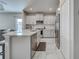 Stylish kitchen with white cabinets, stainless steel appliances, and a view of the living area at 220 Sarezzo Cir, Nokomis, FL 34275