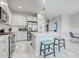 Bright kitchen featuring white cabinets, stainless steel appliances, island with seating, and tile flooring at 220 Sarezzo Cir, Nokomis, FL 34275