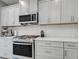 Close-up of kitchen showcasing stainless steel appliances, ample counter space, and white cabinetry at 220 Sarezzo Cir, Nokomis, FL 34275