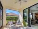 Screened lanai with comfortable seating and view of the backyard at 220 Sarezzo Cir, Nokomis, FL 34275