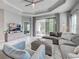 Open-concept living room boasts neutral colors, an oversized couch, and sliding doors to the lanai at 220 Sarezzo Cir, Nokomis, FL 34275