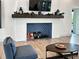 Cozy living room with fireplace decorated with blue tile and a wooden mantle at 220 Sarezzo Cir, Nokomis, FL 34275