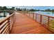 Scenic view of a wooden walkway over a lake with a fountain and lush landscaping at 220 Sarezzo Cir, Nokomis, FL 34275