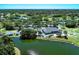 Aerial view of the clubhouse, golf course, and surrounding community, and lake at 2318 Harrier Way, Nokomis, FL 34275
