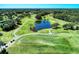 Aerial view showcasing the driving range, golf course, lake and green at 2318 Harrier Way, Nokomis, FL 34275