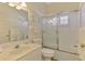 Bright bathroom with a shower-tub combination enclosed by sliding glass doors at 2318 Harrier Way, Nokomis, FL 34275
