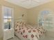 Inviting bedroom with a floral comforter and a large window for natural light at 2318 Harrier Way, Nokomis, FL 34275