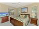 Comfortable bedroom with a floral bedspread, bedside tables, and a peaceful ambiance at 2318 Harrier Way, Nokomis, FL 34275
