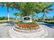 Community entrance with the Calusa Lakes sign, lush landscaping, and palm trees at 2318 Harrier Way, Nokomis, FL 34275