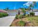 Charming home with a red front door, large garage, and lush landscaping at 2318 Harrier Way, Nokomis, FL 34275