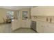 Charming kitchen with stainless steel dishwasher, cream cabinets, and an adjacent breakfast nook at 2318 Harrier Way, Nokomis, FL 34275