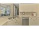 Bright kitchen features stainless steel appliances and a double sink under a window at 2318 Harrier Way, Nokomis, FL 34275