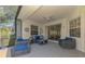 Covered patio featuring comfortable seating arrangements and a ceiling fan for relaxation at 2318 Harrier Way, Nokomis, FL 34275